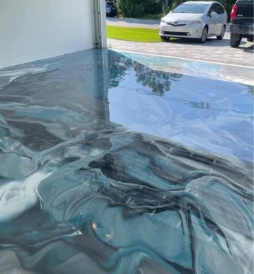 High-gloss resin rich floor with blue ,black and white metallic garage epoxy flooring and a smooth reflective finish