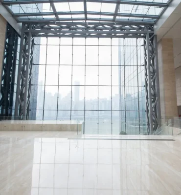 High-gloss resin rich floor with bright off-white commercial epoxy flooring inside a large open industrial-style building.
