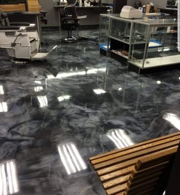 High-gloss resin rich floor with bright white and, grey and black commercial epoxy flooring inside industrial-style building.