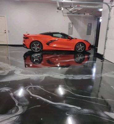 High-gloss resin rich floor with black and white metallic garage epoxy flooring and a smooth reflective finish.
