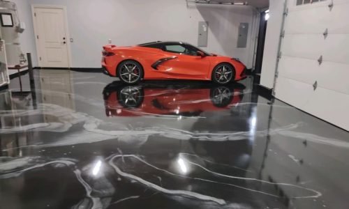 High-gloss resin rich floor with black and white metallic garage epoxy flooring and a smooth reflective finish.