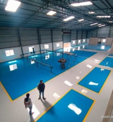High-gloss blue resin rich floor with durable industrial epoxy flooring in a clean and organized industrial facility.
